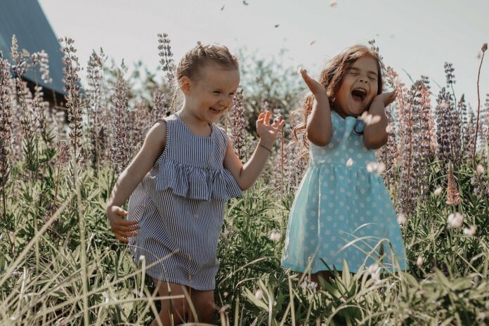 Kinder sielen auf Feld und lachen