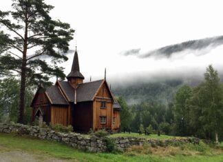 Holzhaus steht in einer Landschaft.