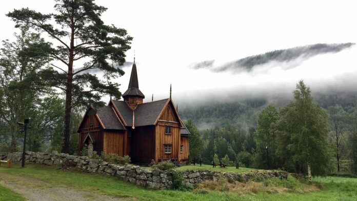 Holzhaus steht in einer Landschaft.