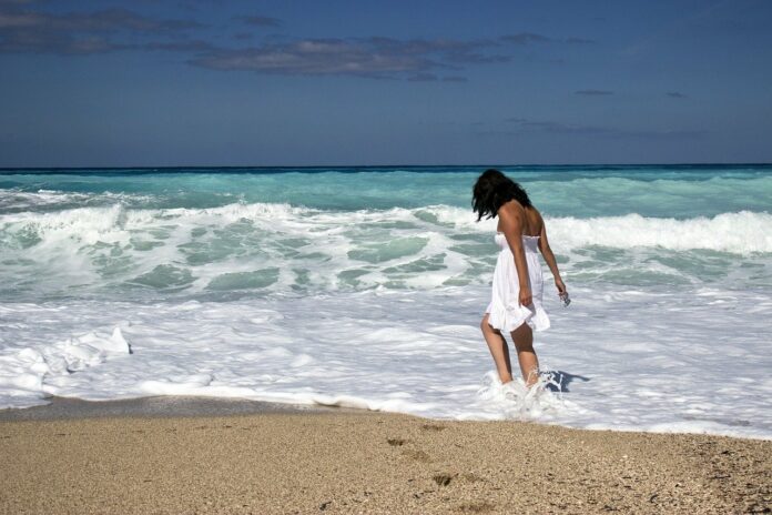 Frau am Strand an Urlaubsort