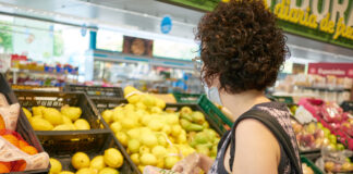 Kundin im Supermarkt beim Obstkauf - die Kundin trägt das frische Obst in einer Plastiktüte. Sie steht in der Obst- und Gemüseabteilung eines Discounters.