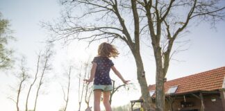 Trampolin mit Mädchen im Garten.