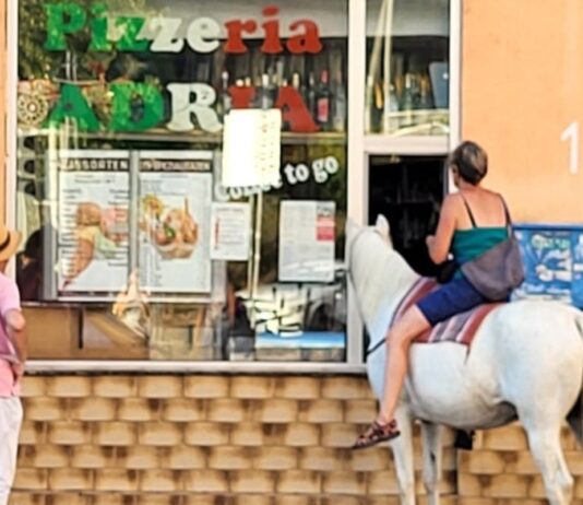 Frau mit Pferd an Eisdiele