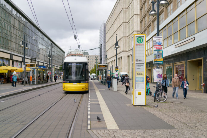 Bahn an Haltestelle mit Reisenden