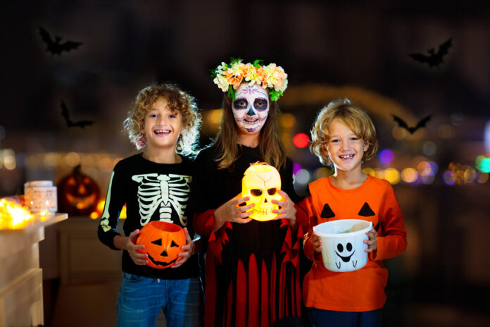 Kinder bitten um Süßigkeiten an Halloween.