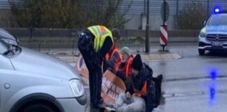 Klimaaktivisten kleben sich auf Straße.