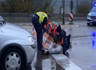 Klimaaktivisten kleben sich auf Straße.