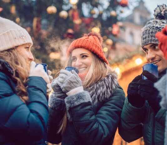 Eine Gruppe trinkt Glühwein auf dem Weihnachtsmarkt.