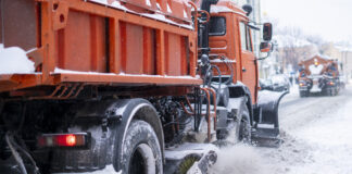 Schneeräumdienst auf verschneiter, vereister Fahrbahn.