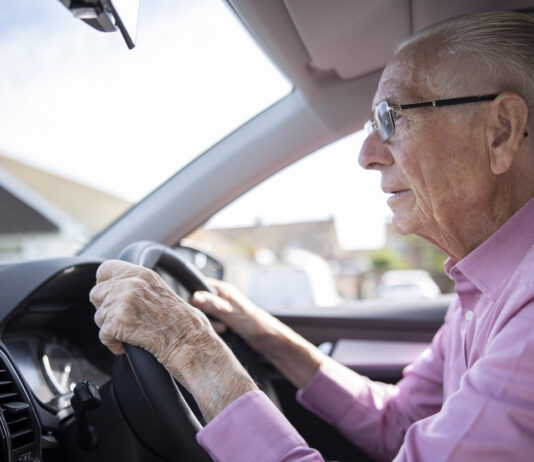 Senior sitzt am Steuer.