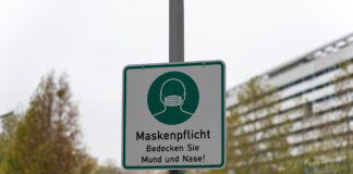 Ein Schild weist auf die Maskenpflicht hin.