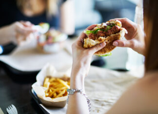 Eine Frau isst einen Burger im Restaurant.