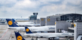 Die Flugzeuge der Lufthansa auf einem Flughafen. Die Flieger stehen am Airport und warten auf ihren Start. Das Bordpersonal befindet sich an Bord.