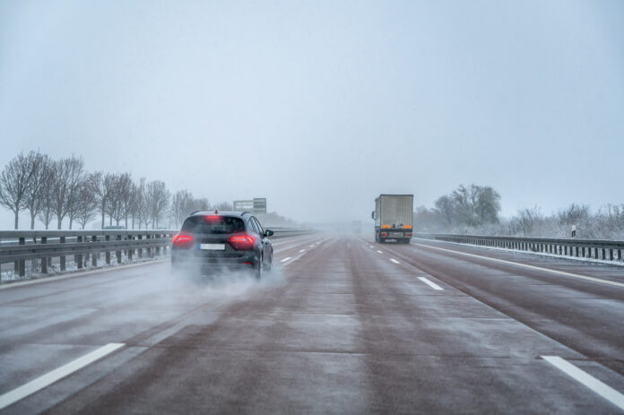 Gefährliches Fahrverhalten eines Autofahrers auf einer Schnellstraße bei schlechtem Wetter.