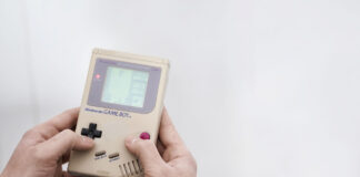 Ein Mann hält einen Gameboy in der Hand