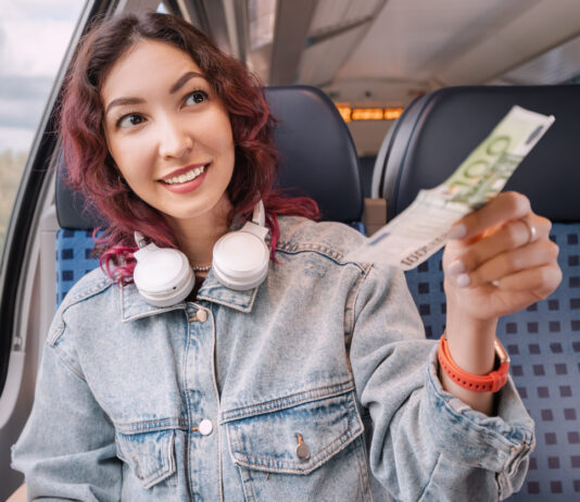 Eine Frau bezahlt mit einem Geldschein in der Bahn