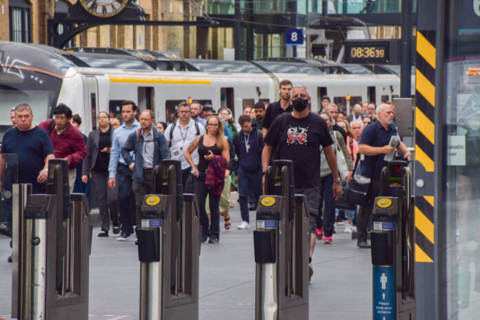 Eine Menge Menschen steigen aus einem Zug oder ein Bus und laufen am Gleis entlang