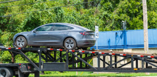 Ein neuer Tesla kommt an und wird vom Sattelschlepper entladen