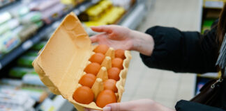 Eine Kundin hält eine Eier-Packung in der Hand.