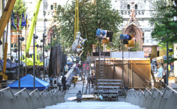 Eine Filmkulisse für einen Dreh in der Innenstadt. Die Kameras und Technik für den Dreh wurde aufgebaut und die Arbeiten beginnen. Passanten dürfen nur von außen bei dem Dreh zuschauen.