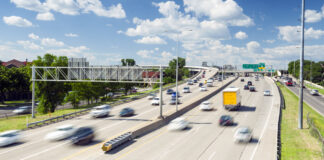 Mehrspurige Autobahn mit fahrenden Fahrzeugen bei mäßigem Verkehr.