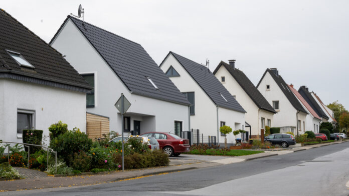 Ein Straßenzug mit mehreren Einfamilienhäusern und Parkbuchten