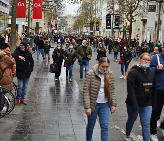 Viele Menschen laufen durch eine Shopping-Meile, in der es eine C&A-Filiale gibt.