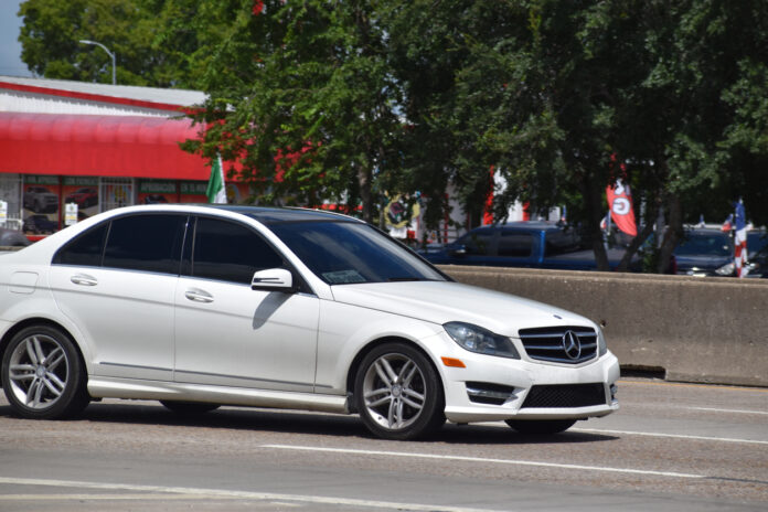 Ein weißer Mercedes mit getönten Scheiben fährt über die Straße