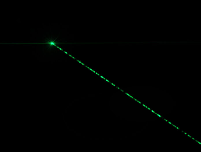 Ein grüner Laserstrahl am Nachthimmel