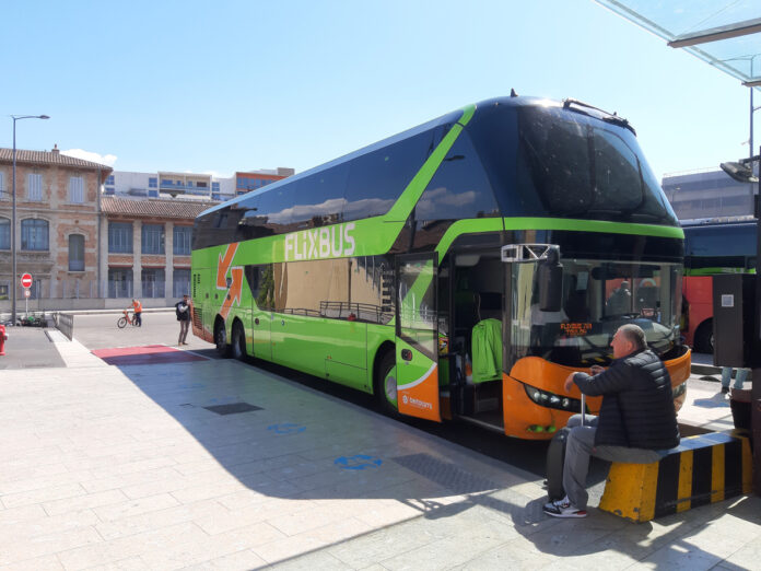 Reisende warten vor einem Flixbus vor der Abfahrt