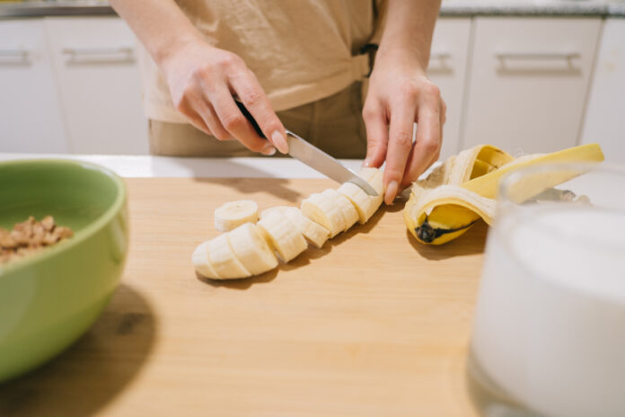 Banane wird in der Küche klein geschnitten