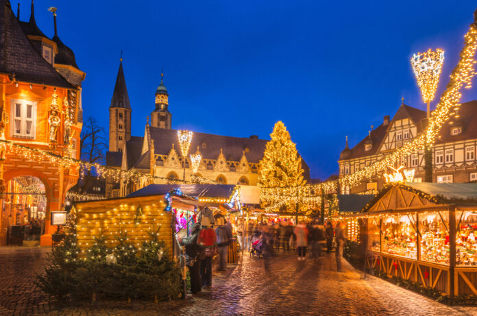 Ein leuchtender Weihnachtsmarkt in der Dämmerung mit vielen Lichtern