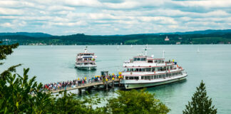 Zwei große Passagierschiffe kommen an einem Hafen auf dem Bodensee oder auf einem anderen See am Ufer an