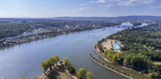 Zusammenfluss von Main und Rhein, Deutschland . Das Bild ist als Panoramablick aus der Luft zu erkennen. In der Ferne sieht man Akcer, Häuser und Siedlungen sowie den Himmel.