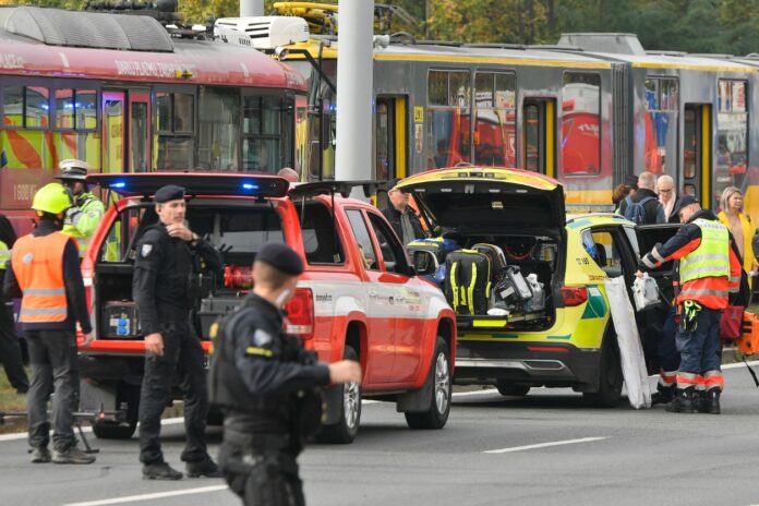 Ein Unfall zwischen einer S-Bahn und einem Auto mit Einsatzfahrzeugen der Polizei. Die Einsatzkräfte sind vor Ort und leisten erste Hilfe. Sie sichern außerdem den Unfallort.