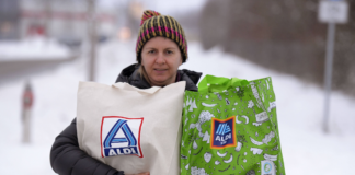 Frau trägt zwei volle Tüten von Aldi