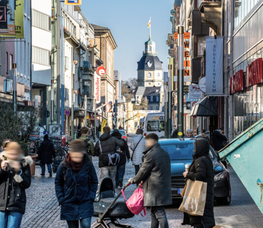 Leute beim Bummeln und Einkaufen in der Karlsruher Innenstadt. Eine Einkaufspassage mit Passanten und Kunden, die an den Läden vorbeischauen und shoppen gehen.