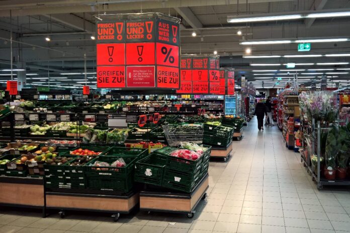 In der Gemüseabteilung eines Supermarktes stehen viele Rabatt-Schilder.