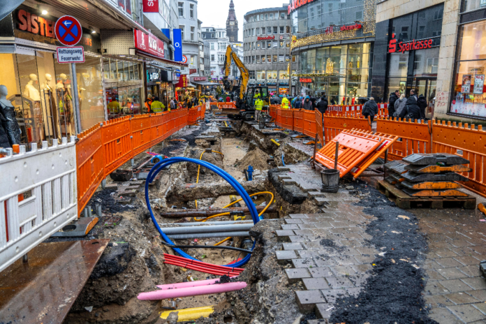 Baustelle bei Wuppertal in der Innenstadt. Die Baufahrzeuge sind angekommen und haben die ganze Straße aufgerissen. Es werden Leitungen im Boden verlegt und dafür auch das Pflaster erneuert.