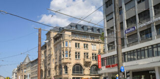 Blick auf die Karlsruher Innenstadt vom Europaplatz aus. Geschäfte, Cafés und Restaurants der City sowie Passanten und Bürger beim Bummeln oder Einkaufen.