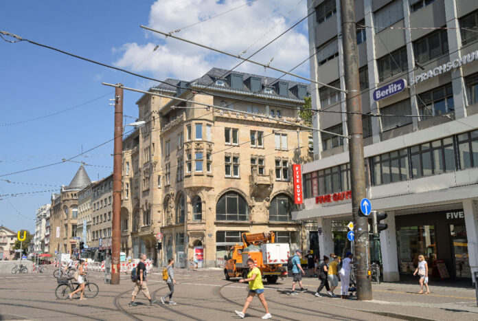 Blick auf die Karlsruher Innenstadt vom Europaplatz aus. Geschäfte, Cafés und Restaurants der City sowie Passanten und Bürger beim Bummeln oder Einkaufen.