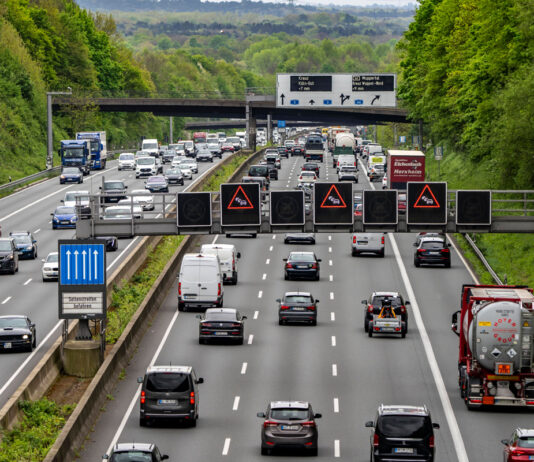 Die A3 bei dichtem Verkehr. Auf beiden Seiten der Straßen sind alle drei Spuren sowie der Seitenstreifen voll mit Autos und LKWs, die alle den Sicherheitsabstand einhalten.