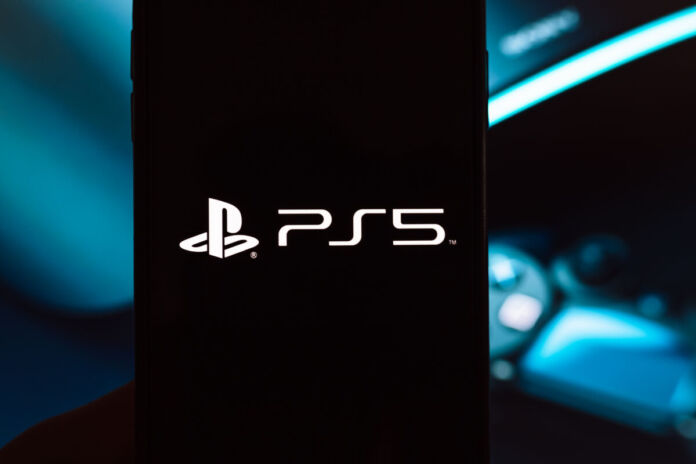 Schwarze PlayStation 5 Gaming Konsole von Sony mit großem Logo. Im Hintergrund verschwommener wireless PS Controller und LED Gaming-Beleuchtung in blau.