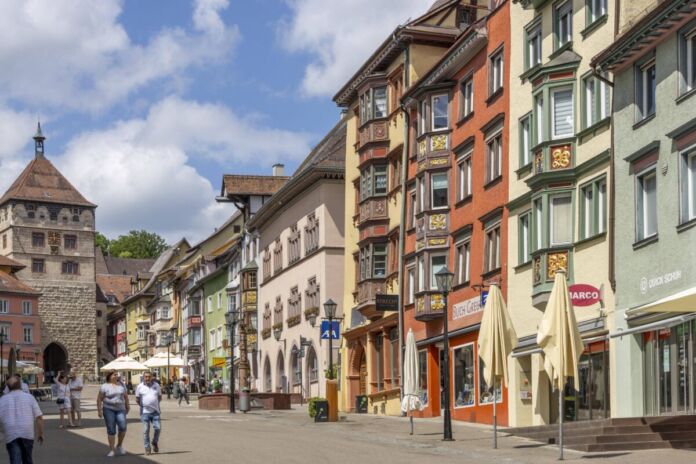 Eine Einkaufsstraße mit verschiedenen bunten Häusern in einer Altstadt in Deutschland. Die Stadt im Schwarzwald ist ein beliebtes Ausflugsziel bei Touristen.