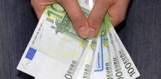 Eine Frau hält fünf grüne Einhundert-Euro-Scheine in der Hand. Es könnte sich dabei um einen Zuschuss handeln, der gerade ausgezahlt wurde und den die Frau bar abgehoben hat.