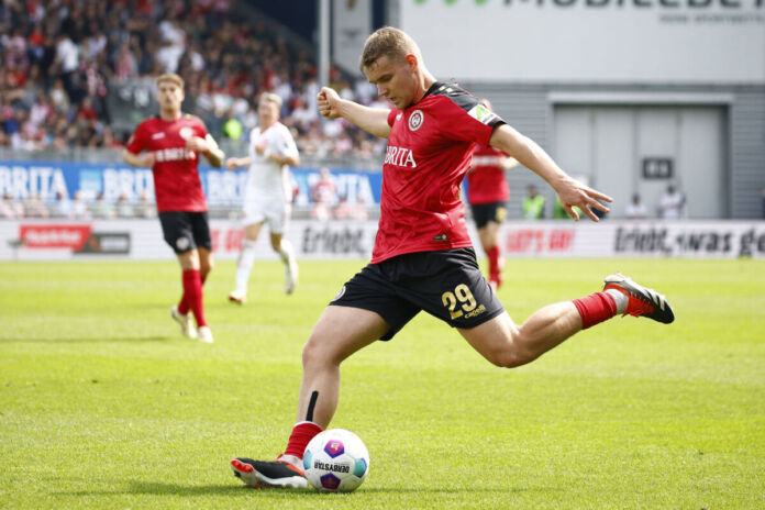 Nachwuchstalent Lasse Günther vom Karlsruher SC bei einer Flanke. Mit dem linken Fuß setzt er auf dem grünen Rasen zur Flanke an.