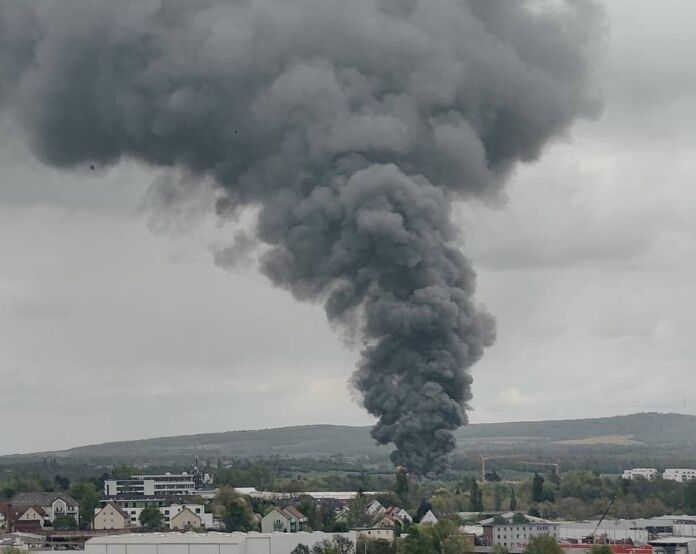 Eine riesige Rauchwolke steigt in den Himmel. Es könnte sich um einen Brand in einer großen Fabrik handeln. Der dicke graue Rauch enthält giftige Pestizide, die die Luft verpesten.