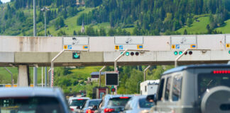 Viele Autos stehen auf der Autobahn im Stau. Einige fahren in den Urlaub. An den Grenzkontrollen kommt es zu langen Wartezeiten.