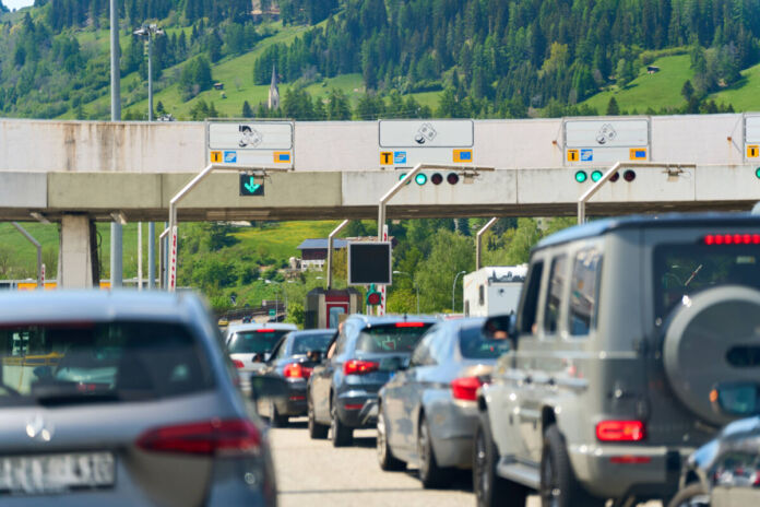 Viele Autos stehen auf der Autobahn im Stau. Einige fahren in den Urlaub. An den Grenzkontrollen kommt es zu langen Wartezeiten.