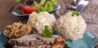 Auf dem Teller liegen Schweinebraten, Soße und Knödel zusammen. Das ist ein traditionelles Gericht aus der Wirtsstube. Auch in vielen Brauereien steht es auf der Speisekarte. Im Mittelpunkt steht das Fleisch.